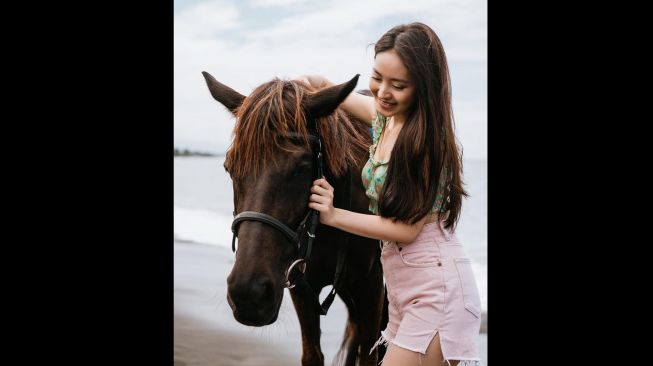 Aktris Natasha Wilona menunggangi kuda di tepi Bali saat berlibur di Bali. [instagram/@natashawilona12]