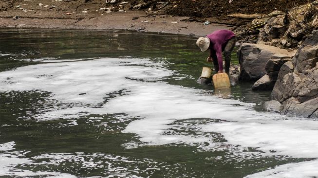 Seorang warga mengambil air Sungai Citarum di Curug Jompong, Kabupaten Bandung Barat, Jawa Barat, Rabu (31/8/2022). [ANTARA FOTO/Novrian Arbi/wsj]