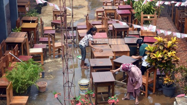 Sejumlah guru dan pegawai sekolah membersihkan meja dan kursi yang basah pasca banjir di SMK Nusantara, Kota Bogor, Jawa Barat, Rabu (31/8/2022). [ANTARA FOTO/Arif Firmansyah/aww]
