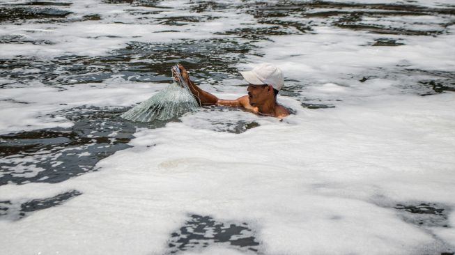 Seorang warga menjaring ikan di Sungai Citarum di Curug Jompong, Kabupaten Bandung Barat, Jawa Barat, Rabu (31/8/2022). [ANTARA FOTO/Novrian Arbi/wsj]