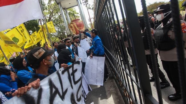 Polisi berjaga saat mahasiswa berorasi dalam unjuk rasa di depan kantor Gubernur Provinisi Kalimantan Tengah di Palangka Raya, Kalimantan Tengah, Jumat (2/9/2022).  ANTARA FOTO/Makna Zaezar
