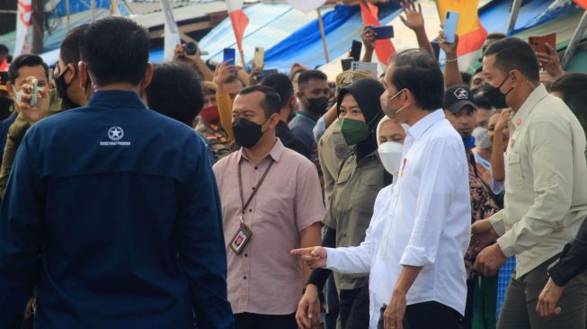 Presiden Joko Widodo (tengah) memberikan bantuan pada pedagang saat mengunjungi Pasar Ngrimase Olilit, Tanimbar Selatan, Kabupaten Kepulauan Tanimbar, Maluku, Jumat (2/9/2022).  ANTARA FOTO