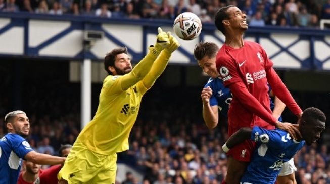 Kiper Liverpool Alisson Becker mematahkan peluang Everton dalam pertandingan Liga Inggris di Goodison Park, Sabtu (3/9/2022). [AFP]