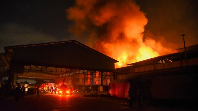 Petugas berupaya memadamkan api yang membakar pabrik plastik di Jalan Setia Ujung, Sungal, Deli Serdang, Sumatera Utara, Jumat (2/9/2022) malam. ANTARA FOTO/Fransisco Carolio