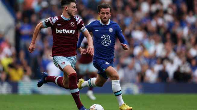 Gelandang West Ham United Declan Rice (kiri) berebut bola dengan bek Chelsea Ben Chilwell saat pertandingan sepak bola Liga Premier Inggris antara Chelsea dan West Ham United di Stamford Bridge, London, Inggris, Sabtu (3/9/2022). [ADRIAN DENNIS / AFP]
