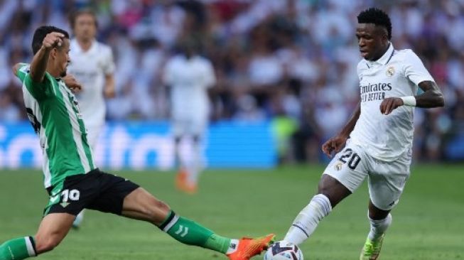 Penyerang Real Madrid Vinicius Junior berebut bola dengan pemain Real Betis pada  pertandingan Liga Spanyol di Stadion Santiago Bernabeu di Madrid pada 3 September 2022. [AFP/THOMAS COEX]