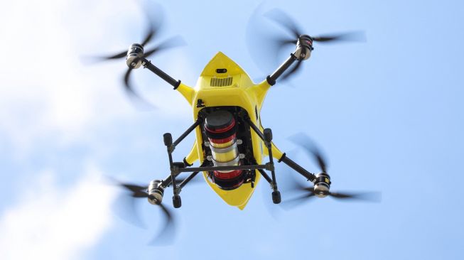 Drone dari perusahaan Helicus membawa sampel jaringan manusia di atas area perkotaan saat uji coba di rumah sakit Network Antwerp (ZNA) di Antwerp, Belgia, Selasa (23/8/2022). [Kenzo TRIBOUILLARD / AFP]