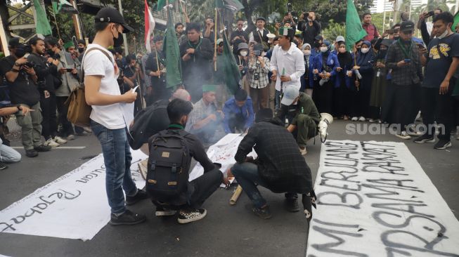 Massa Mahasiswa membakar miniatur keranda saat aksi unjuk rasa menolak kenaikan harga BBM di kawasan Silang Monas, Jakarta Pusat, Senin (5/9/2022). [Suara.com/Alfian Winanto]