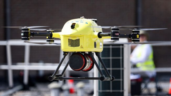 Drone dari perusahaan Helicus membawa sampel jaringan manusia di atas area perkotaan saat uji coba di rumah sakit Network Antwerp (ZNA) di Antwerp, Belgia, Selasa (23/8/2022). [Kenzo TRIBOUILLARD / AFP]