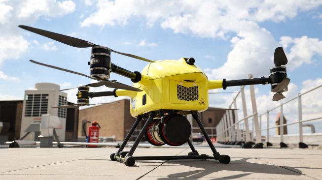 Drone dari perusahaan Helicus membawa sampel jaringan manusia di atas area perkotaan saat uji coba di rumah sakit Network Antwerp (ZNA) di Antwerp, Belgia, Selasa (23/8/2022). [Kenzo TRIBOUILLARD / AFP]