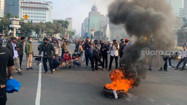 Massa gabungan GPI, HMI dan PMII bakar ban dalam aksi demo tolak BBM naik di kawasan Patung Kuda, Monas, Jakarta Pusat, Senin (5/9/2022). [Suara.com/Yaumal Asri Adi Hutasuhut]