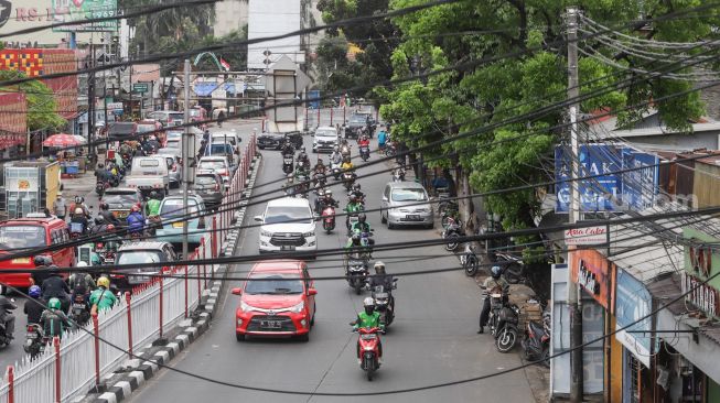 Deretan instalasi kabel yang semrawut di Kramat Jati, Jakarta Timur, Selasa (6/9/2022). [Suara.com/Alfian Winanto]