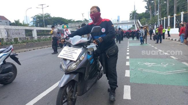 Massa buruh demo tolak kenaikan BBM dengan mendorong sepeda motor ke gedung DPR RI. (Suara.com/Bagaskara)