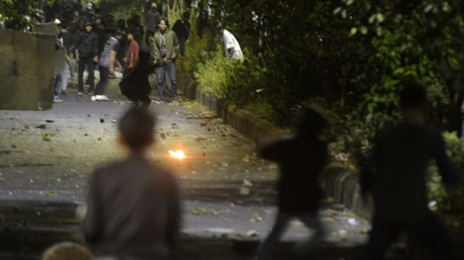 Sejumlah mahasiswa terlibat bentrok dengan sekelompok warga saat berunjuk rasa di depan kampus Universtas Negeri Makassar (UNM), Makassar, Sulawesi Selatan, Senin (5/9/2022) malam. Unjuk rasa mahasiswa menolak kenaikan harga Bahan Bakar Minyak (BBM) tersebut berujung bentrok dan sejumlah mahasiswa diamankan. ANTARA FOTO/Abriawan Abhe/wsj.