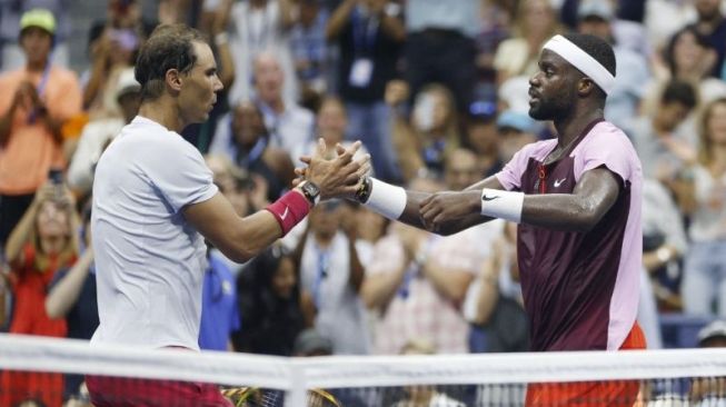 Petenis Amerika Serikat Frances Tiafoe berjabat tangan dengan petenis Spanyol Rafael Nadal setelah babak keempat US Open 2022 di USTA Billie Jean King National Tennis Center, Flushing, Queens, New York City, 5 September 2022. (Getty Images via AFP/SARAH STIER)