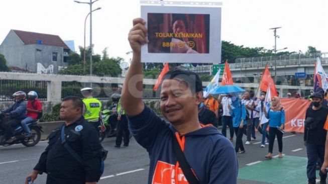 Massa buruh bawa poster bergambar Puan Maharani menangis karena BBM naik. (Suara.com/Bagaskara)