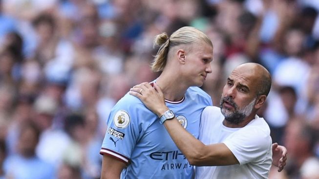 Manajer Manchester City asal Spanyol Pep Guardiola (kanan) memberi selamat kepada striker Manchester City asal Norwegia Erling Haaland saat ia meninggalkan lapangan selama pertandingan Liga Premier Inggris antara Manchester City vs Bournemouth di Stadion Etihad di Manchester, barat laut Inggris, pada 13 Agustus 2022.Oli SCARFF / AFP