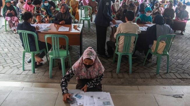 Petugas mengecek data warga penerima manfaat saat penyaluran Bantuan Langsung Tunai (BLT) bahan bakar minyak (BBM) dan sembako di Kantor Pos Palangka Raya, Kalimantan Tengah, Kamis (8/9/2022). ANTARA FOTO/Makna Zaezar/hp.