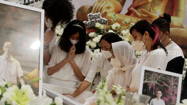 Keluarga berdoa disamping peti jenazah Reza Gunawan di Rumah Duka Grand Heaven, Jakarta, Kamis (8/9). [Suara.com/Oke Atmaja]