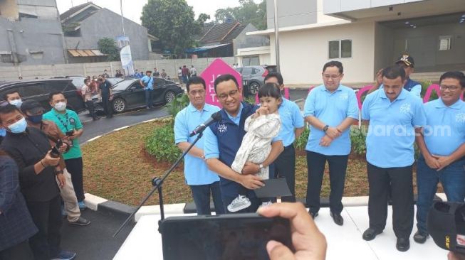 Gubernur DKI Jakarta Anies Baswedan saat mengajak ngobrol penghuni rumah susuh DP 0 rupiah sembari menggendong anak. (Suara.com/Fakhri)