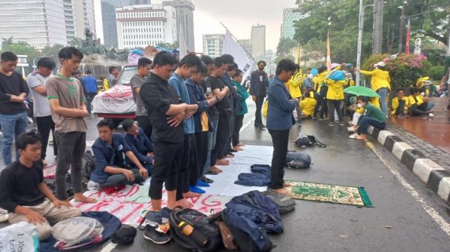 Sebelum Orasi Tolak Kenaikan Harga BBM, Demonstran Salat Zuhur Berjemaah di Patung Kuda Saat Hujan Mengguyur