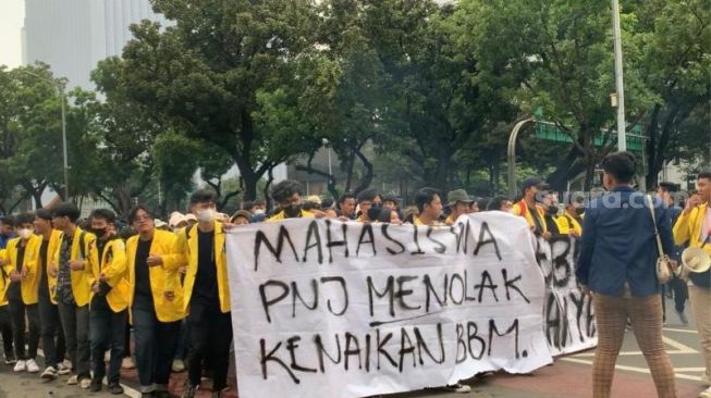 Massa BEM SI saat long march sembari dorong motor ke kawasan Patung Kuda, Jakarta. (Suara.com/Rakha)