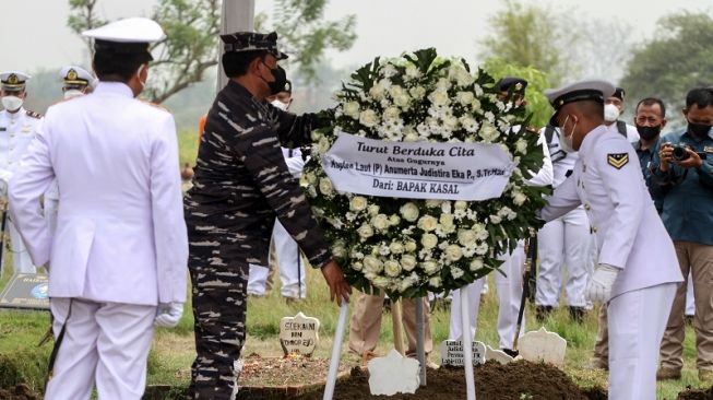 Kepala Staf Angkatan Laut (KSAL) Laksamana TNI Yudo Margono (kedua kiri) meletakkan karangan bunga di makam Pilot Kapten Laut (P) Anumerta Judistira Eka Permady dan CoPilot Lettu Laut (P) Anumerta Dendy Kresna Bakti Sabila saat prosesi pemakaman jenazah di Taman Makam Bahagia TNI AL Desa Gisikcemandi Sedati, Sidoarjo, Jawa Timur, Jumat (9/9/2022).  [ANTARA FOTO/Umarul Faruq/rwa].