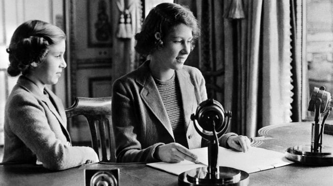 Gambar yang diambil Oktober 1940 di Windsor menunjukkan Putri Elizabeth dari Inggris (calon Ratu Elizabeth II) dan saudara perempuannya Putri Margaret mengirim pesan selama program anak-anak BBC, terutama kepada anak-anak yang dievakuasi karena Perang Dunia II.
KOLAM RENANG / AFP