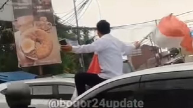 Pria Duduk di Atas Mobil Kibarkan Bendera dan Teriak 'Saya Dibunuh Pemerintah' Publik: Kasian Masih Muda Sudah Suram