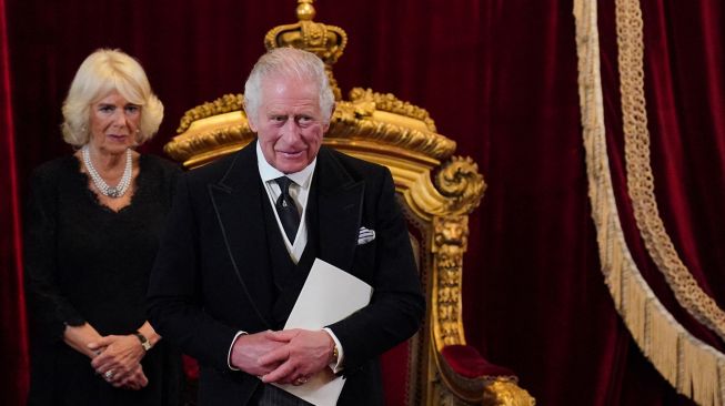 Permaisuri Camilla dan Raja Inggris Charles III tersenyum selama pertemuan Dewan Aksesi untuk menyatakan Charles sebagai Raja baru di dalam Istana St James di London, Inggris, Sabtu (10/9/2022). [Jonathan Brady / POOL / AFP]