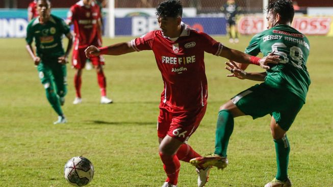 Pesepak bola Persis Solo Alfath Faathier (kiri) berebut bola dengan pesepak bola PSS Sleman Derry Rachman (kanan) pada pertandingan Liga 1 di Stadion Maguwoharjo, Sleman, DI Yogyakarta, Sabtu (10/9/2022). [ANTARA FOTO/Hendra Nurdiyansyah/rw]