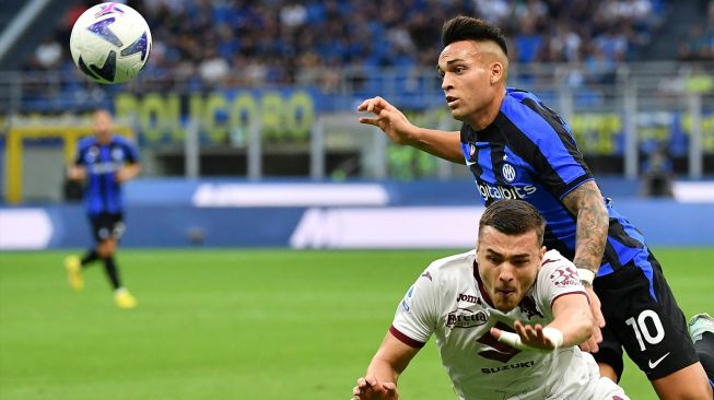 Penyerang Inter Milan Lautaro Martinez (Atas) berebut bola dengan bek Torino Alessandro Buongiorno saat pertandingan sepak bola Serie A Liga Italia antara Inter Milan dan Torino di stadion San Siro, Milan, Italia, Sabtu (10/9/2022). [Isabella BONOTTO / AFP] 
