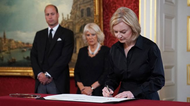 Perdana Menteri Inggris Liz Truss menandatangani Proklamasi Aksesi Raja Charles III saat pertemuan Dewan Aksesi di dalam Istana St James di London, Inggris, Sabtu (10/9/2022). [Kirsty O'Connor / POOL / AFP]