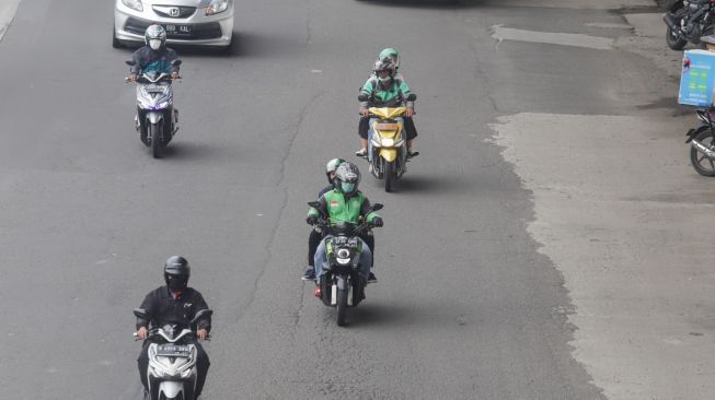 Pengendra Ojek Online melintas di Jalan Gatot Subroto, Jakarta Selatan, Senin (12/9/2022). [Suara.com/Alfian Winanto]