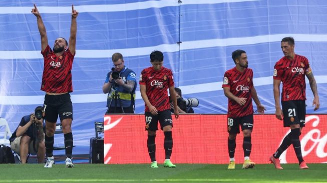 Para pemain Real Mallorca merayakan gol ke gawang Real Madrid pada laga Liga Spanyol di Stadion Santiago Bernabeu, Madrid, Spanyol, Minggu (11/9/2022) malam WIB. [Thomas COEX / AFP]