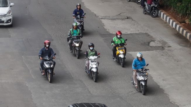 Pengendra Ojek Online melintas di Jalan Gatot Subroto, Jakarta Selatan, Senin (12/9/2022). [Suara.com/Alfian Winanto]