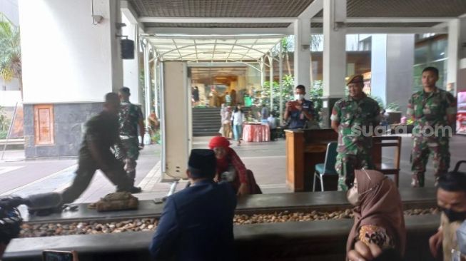 Gubernur DKI Jakarta saat menemui ibu berkursi roda sebelum mendatangi gedung DPRD DKI. Anies didampingi Wagub DKI Ahmad Riza Patria untuk menghadir rapat paripurna pengumuman pemberhentian masa jabatan gubernur di DPRD DKI Jakarta. (Suara.com/Fakhri)