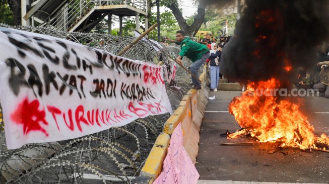 Massa aliansi mahasiswa, pelajar dan sejumlah elemen buruh mencoba merubuhkan kawat duri saat melakukan aksi unjuk rasa menolak kenaikan harga BBM di kawasan Patung Kuda, Jakarta Pusat, Selasa (13/9/2022). [Suara.com/Alfian Winanto]