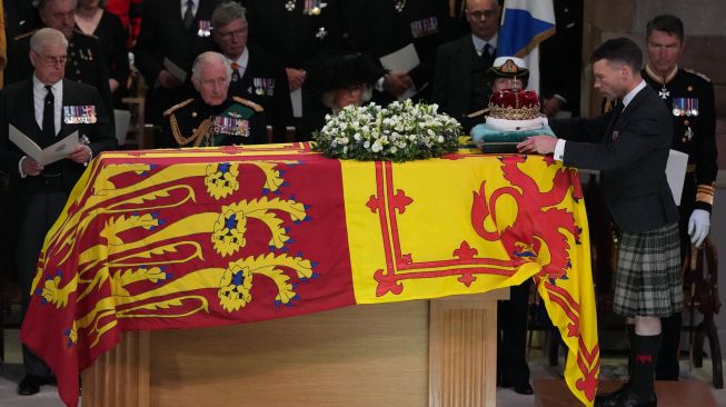 Raja Inggris Charles III dan keluarga kerajaan lainnya menempatkan Mahkota Skotlandia di atas peti mati Ratu Elizabeth II di Katedral St Giles di Edinburgh, Skotlandia, Senin (12/9/2022). [Aaron Chown / POOL / AFP]