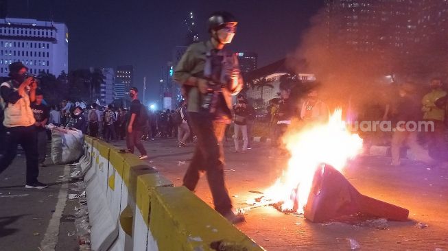 Aksi bakar ban mewarnai demo massa mahasiswa tolak kenaikan BBM di kawasan Patung Kuda, Jakarta Pusat, Selasa (13/9/2022). [Suara.com/Faqih Fathurrahman]