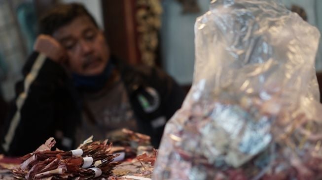 Seorang warga Solo Samin memeriksa uang miliknya yang rusak dimakan rayap saat mendatangi Kantor Bank Indonesia, Solo, Jawa Tengah, Selasa (13/9/2022). [ANTARA FOTO/Mohammad Ayudha/aww].