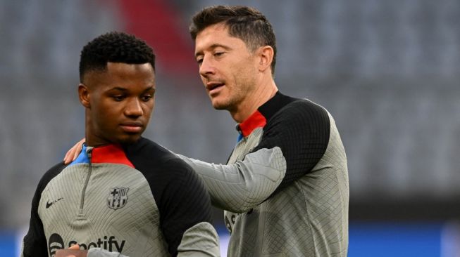 Dua penyerang Barcelona, Robert Lewandowski (kanan) dan Ansu Fati melakoni sesi latihan di Allianz Arena, Munich, Jerman, Senin (12/9/2022) waktu setempat. [Christof STACHE / AFP]