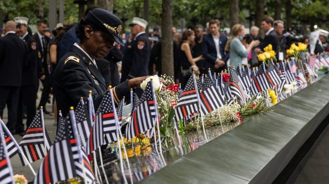 Kolonel Davis meletakkan karangan bunga untuk rekannya Kapten Micheal Dermott Mullan yang tewas saat Peringatan 9/11 di New York, Amerika Serikat, Minggu (11/9/2022). [Yuki IWAMURA / AFP]
