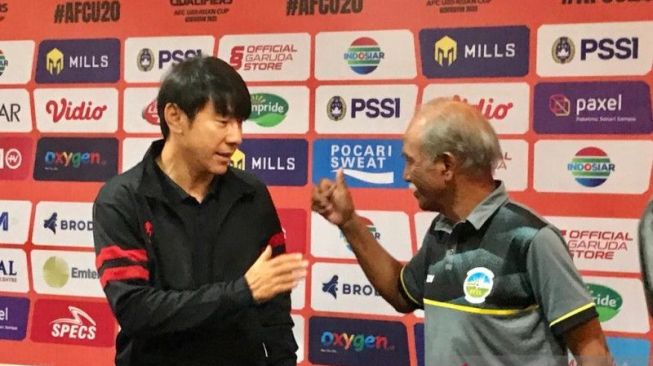 Pelatih Timnas Indonesia Shin Tae-yong (kiri) bersalaman dengan Pelatih Timor Leste, Gopalkrishnan A S Ramasamy (kanan) saat konferensi pers menjelang laga perdana grup F babak kualifikasi Piala Asia U-20 di Surabaya, Selasa (13/9/2022). ANTARA/Fiqih Arfani.