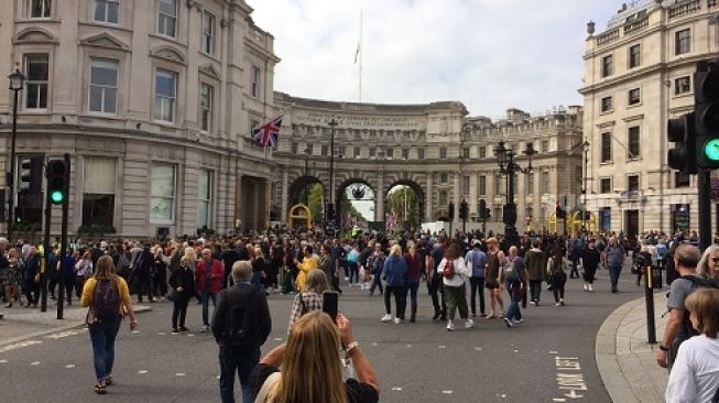Keramaian massa menuju The Mall dan Buckingham Palace saat seremoni pengantaran jasad Ratu Elizabeth II ke Westminster Hall lewat tengah hari (14/9/2022) [Suara.com/Nicholas Ingram CNR ukirsari].