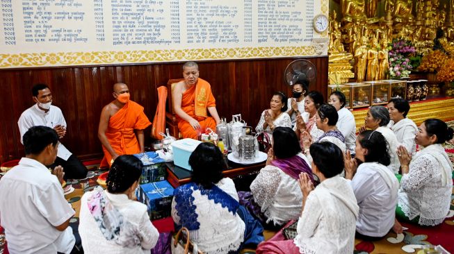 Umat Buddha berdoa saat mereka menawarkan makanan kepada Biksu selama festival Pchum Ben (Festival Kematian) di sebuah pagoda di Phnom Penh, Kamboja, Selasa (13/9/2022). [TANG CHHIN Sothy / AFP]