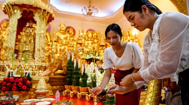 Para wanita membakar dupa saat mereka berdoa selama festival Pchum Ben (Festival Kematian) di sebuah pagoda di Phnom Penh, Kamboja, Selasa (13/9/2022). [TANG CHHIN Sothy / AFP]
