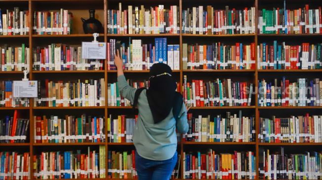 Pengunjung memilih buku di perpustakaan "Baca Di Tebet", Jakarta Selatan, Rabu (14/5/9/2022). [Suara.com/Alfian Winanto]