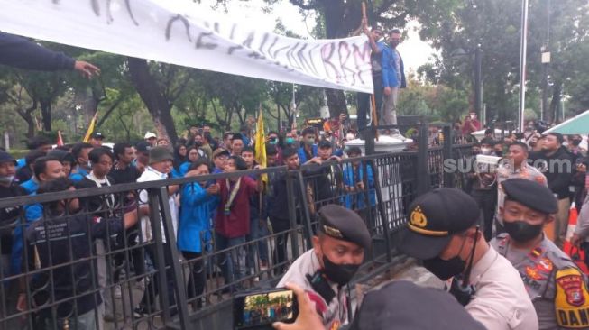 Massa PCPMII saat berdemonstrasi di depan gedung Balai Kota Jakarta. (Suara.com/Fakhri)