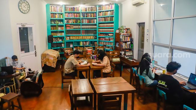 Pengunjung membaca buku di perpustakaan "Baca Di Tebet", Jakarta Selatan, Rabu (14/5/9/2022). [Suara.com/Alfian Winanto]